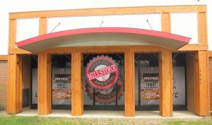 Pizza restaurant storefront at Yellowstone National Park, featuring a wooden facade and curved red awning.