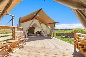 Exterior view of the lodge with canvas tents nestled among pines