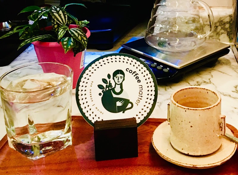Cafe counter with a glass of water, cup and sign inside a park cafe in Acadia National Park.