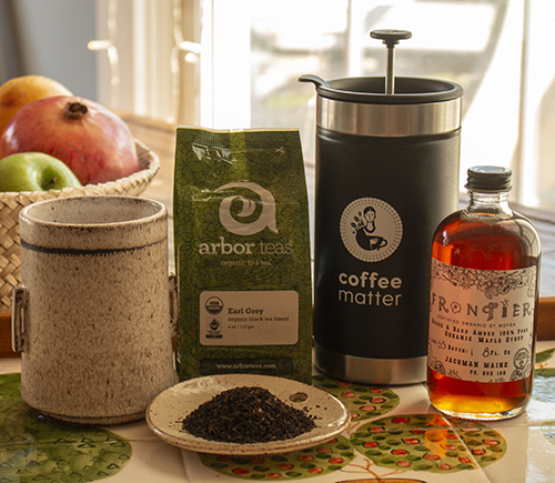 Indoor coffee and tea gear on a breakfast table in Acadia National Park, with fruit and a moka pot nearby.