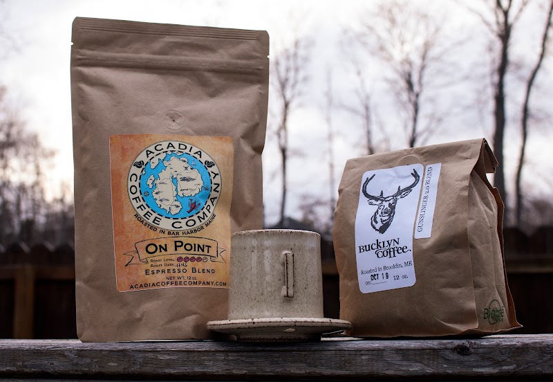 On Point coffee bags sit on a railing along a wooden overlook in Acadia National Park.