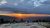 Sunset over Cadillac Mountain Overlook in Acadia National Park with visitors gathered on smooth granite slabs.