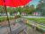 Lodge deck with a glass table and chairs overlooking a row of cabins with red doors in Acadia National Park.