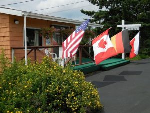 Exterior of a motel near Bar Harbor in Acadia National Park with American, Canadian and other flags displayed near the entrance.