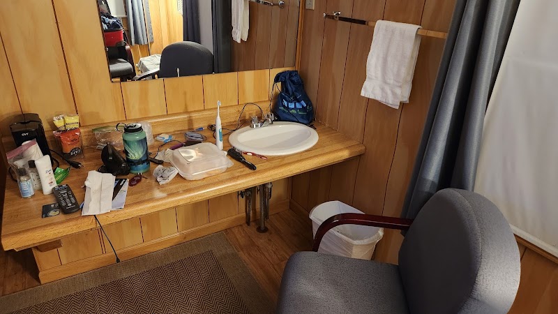 Motel bathroom vanity in Acadia National Park, cluttered counter with toiletries and sink.