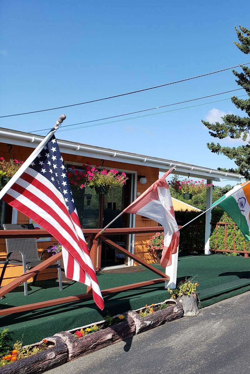 Acadia Gateway Motel porch in Acadia National Park, flags fluttering beside a flower-filled deck.