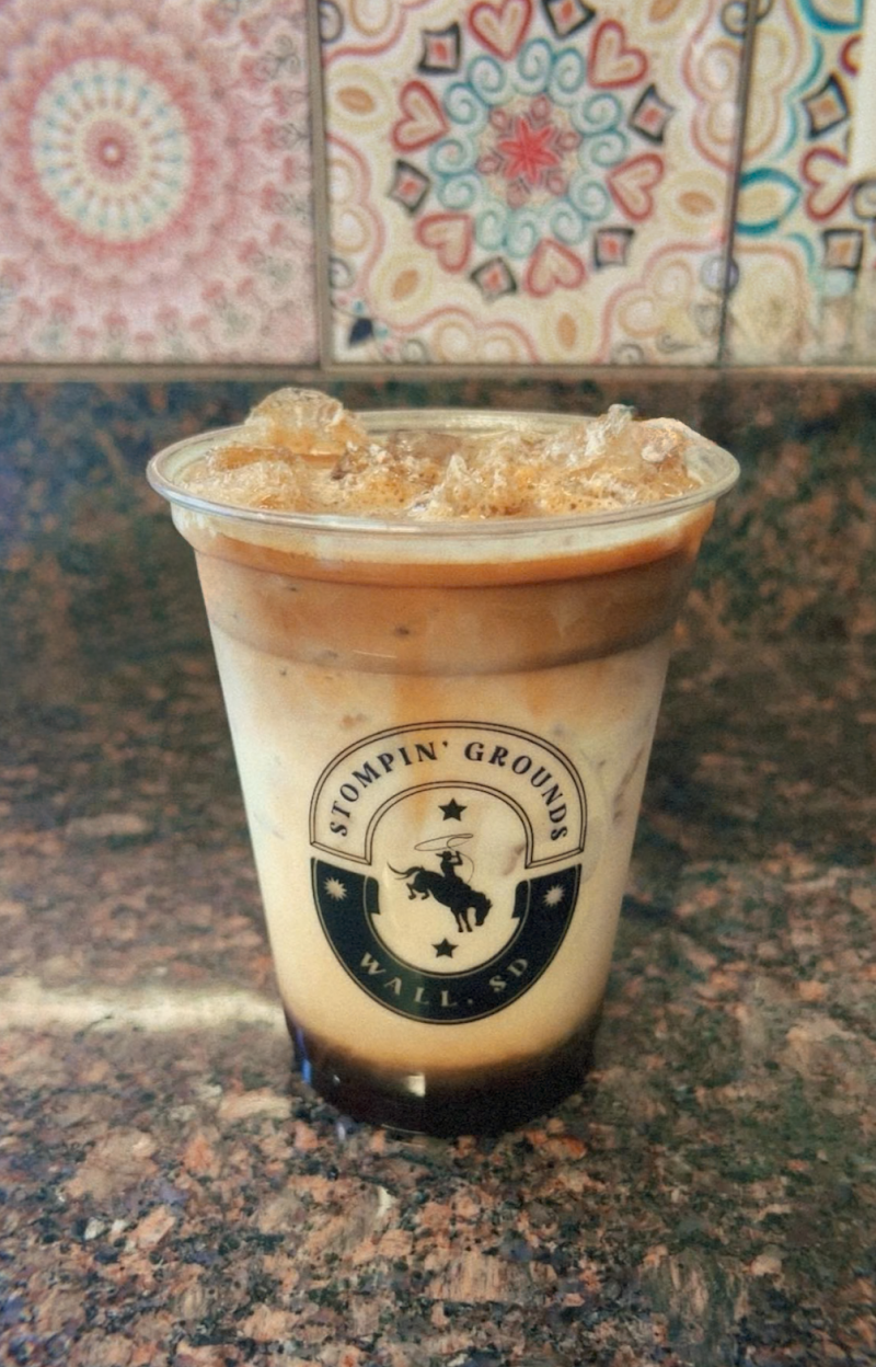 Warm-lit interior with wooden tables, plants, and comfortable seating