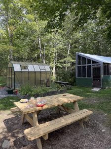 Picnic table near a greenhouse and cabin dining area at Acadia National Park