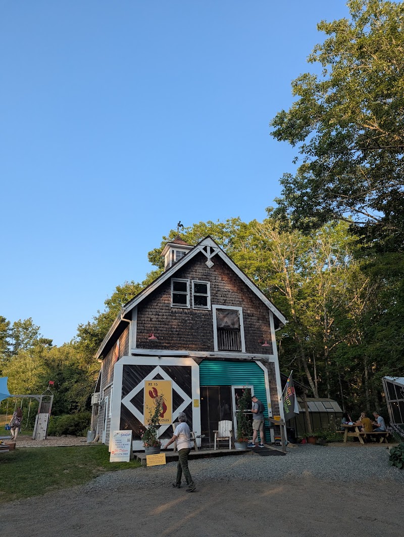 El El Frijoles restaurant housed in a rustic wooden building at Acadia National Park, Maine, with blue sky and green trees backdrop.