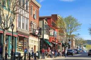Quaint Bar Harbor storefronts along a sunny street near Acadia National Park, with harbor-town charm.