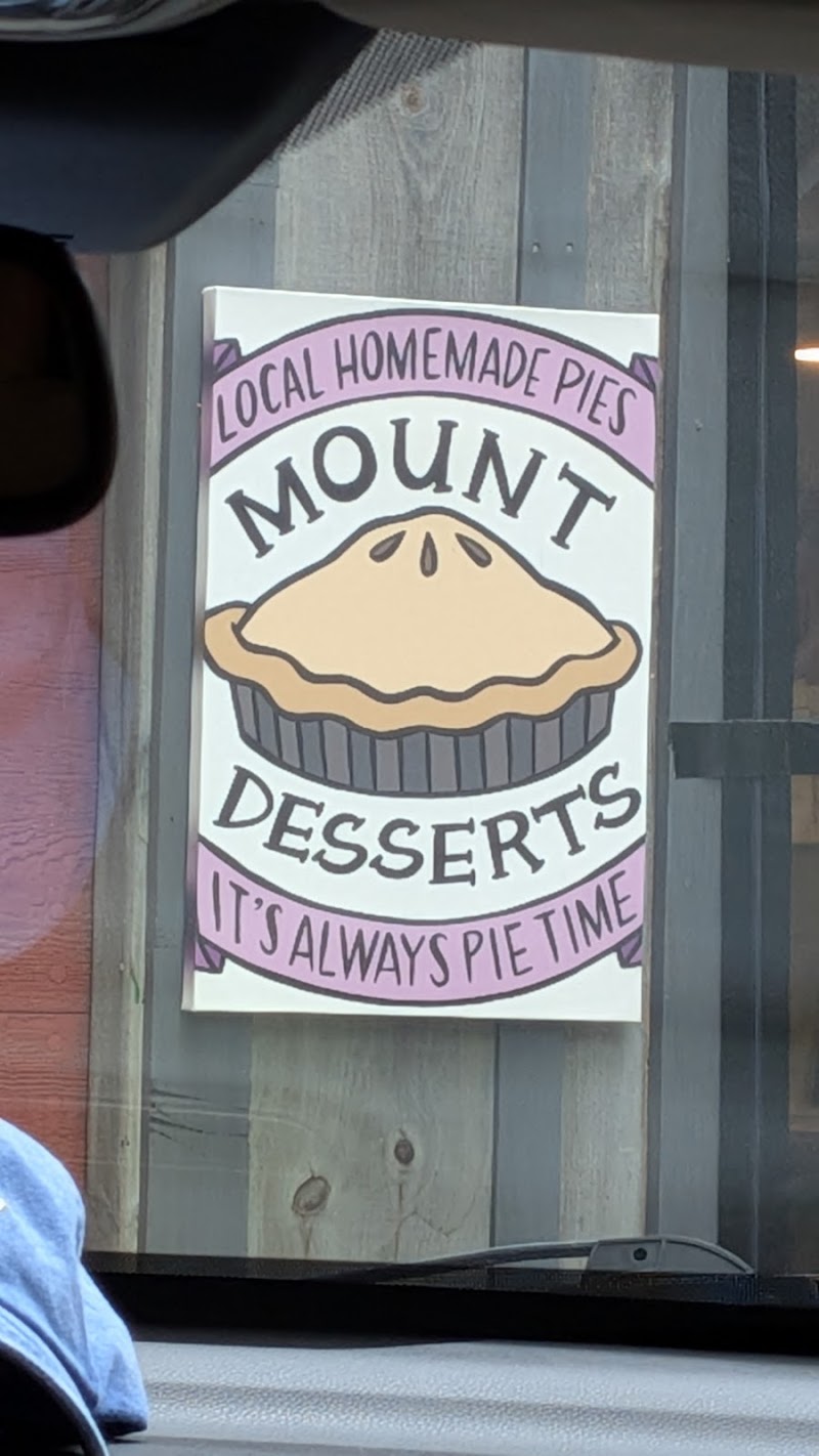 Sign on a weathered wooden wall advertising local homemade pies with a large pie illustration outside a shop in Acadia National Park.
