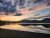Sunset over Rainbow Point Campground at Yellowstone National Park, with calm lake reflections and distant rugged mountains.