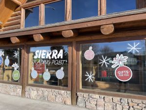 Gift shop exterior in Yellowstone National Park with wooden lodge-style facade and festive window decals.