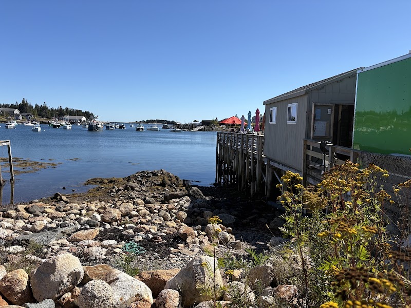 Lunch on the Wharf at Acadia National Park along a rocky shoreline with boats moored in a calm harbor.