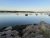 Gouldsboro Harbor view in Acadia National Park shows calm water, anchored boats, and rocky shoreline.
