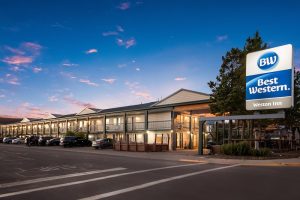 Exterior view of the lodging facade with a covered entrance and parking