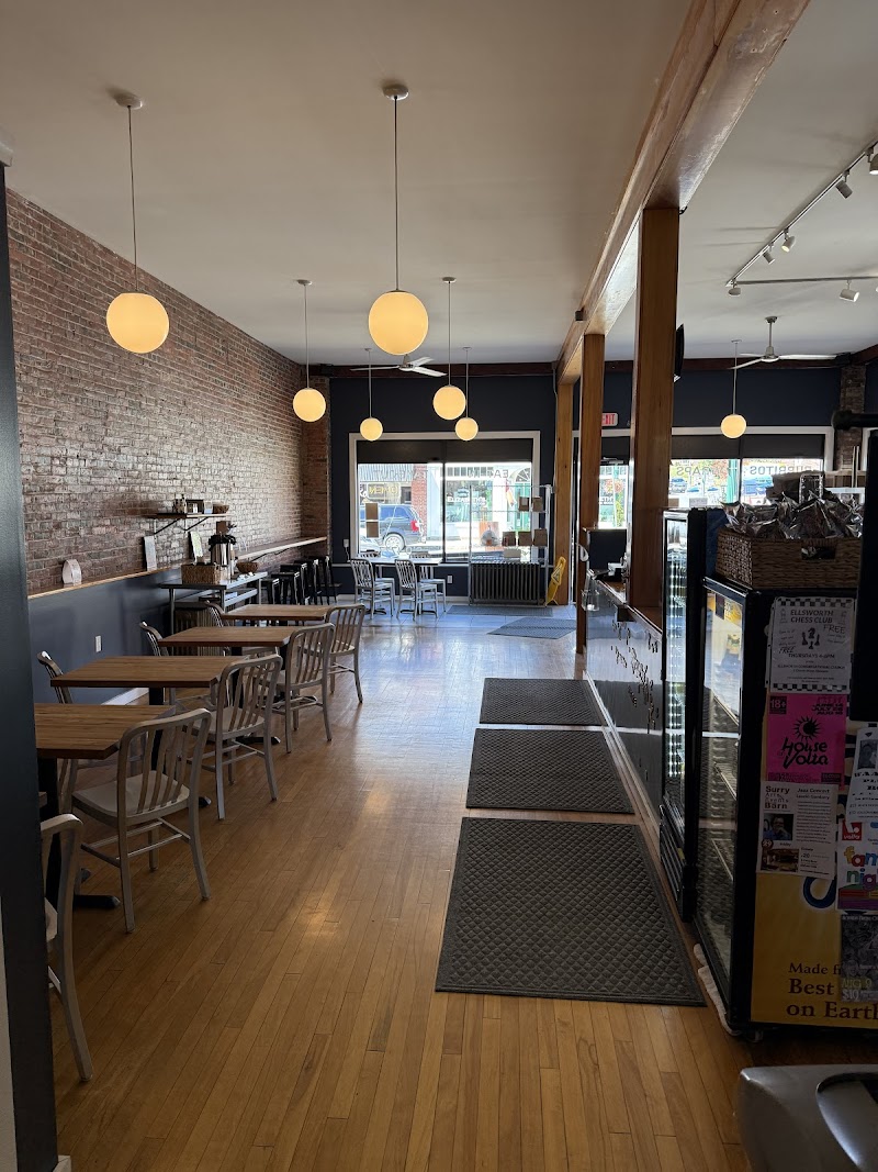 Cozy dining space inside a cafe-style restaurant in Acadia National Park, with brick walls, pendant lights, and wooden tables.