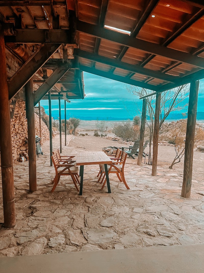Covered lodge patio at The Summit at Big Bend overlooking the desert landscape and distant mountains.