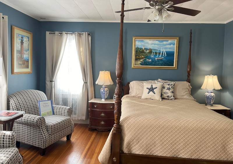 Cozy inn bedroom with sea-blue walls, a four-poster bed, and nautical accents in Acadia National Park.