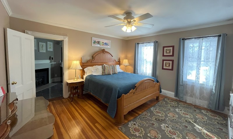 Cozy waterfront inn bedroom in Acadia National Park featuring a carved wooden bed and soft lighting.