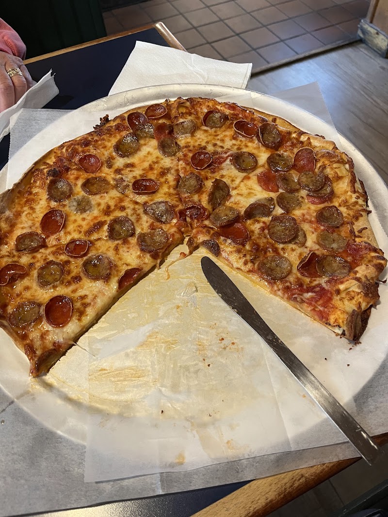 Pepperoni pizza served at a dining table near Acadia National Park, with melted cheese and pepperoni slices.