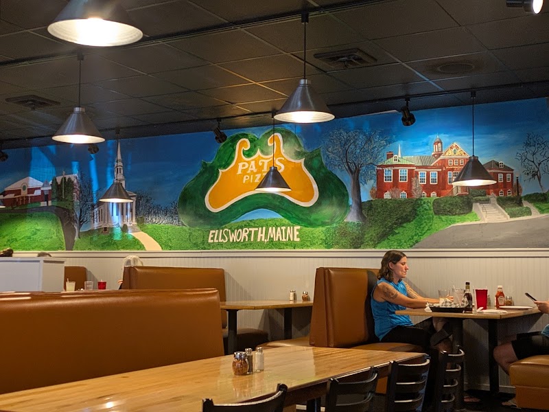 Interior of a pizza restaurant in Ellsworth, Acadia National Park, with a colorful mural.