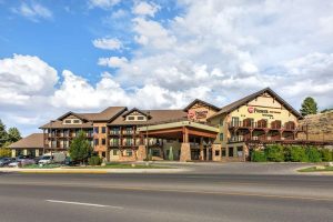 Lodge-style hotel exterior at Yellowstone National Park with stone and wood facade and a covered entrance.