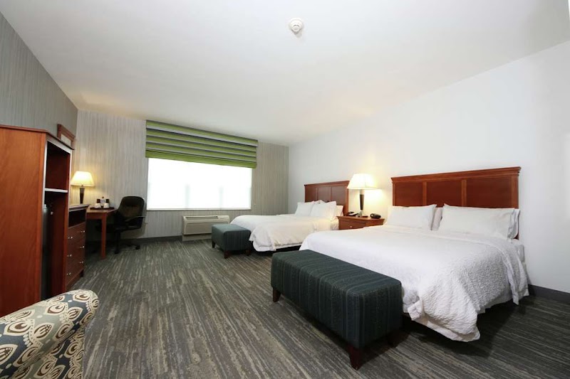 Guest room interior at a lodging near Acadia National Park with two queen beds and dark wood furnishings.