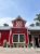 Bright red wooden gift shop building in Glacier National Park, with white-trimmed windows and potted flowers.