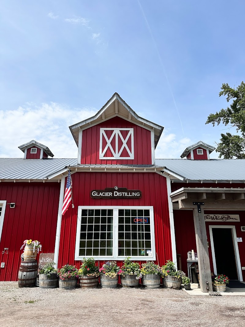Bright red wooden gift shop building in Glacier National Park, with white-trimmed windows and potted flowers.