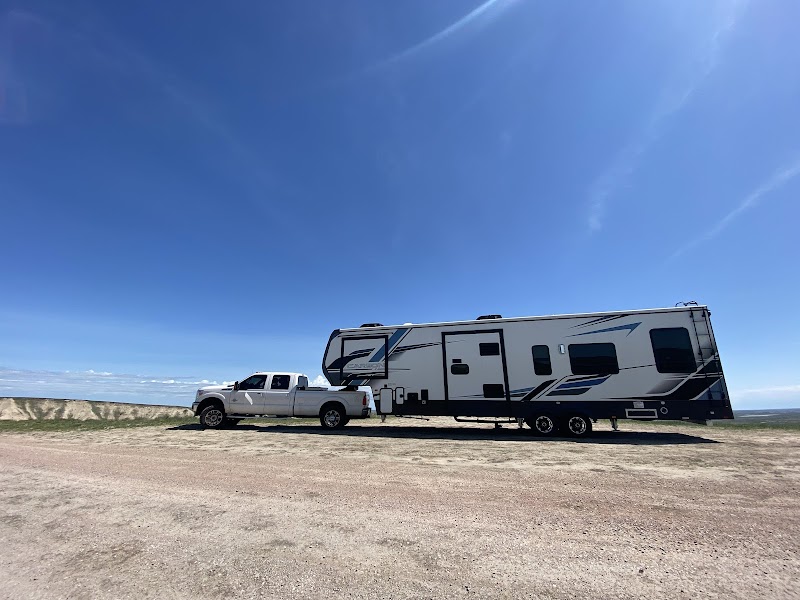 Sunset over the campsite with silhouettes of tents and vehicles