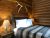 Cozy lodge bedroom at Elkhorn Cabins and Inn featuring a wooden headboard, white pillows, and antler decor in Yellowstone National Park.