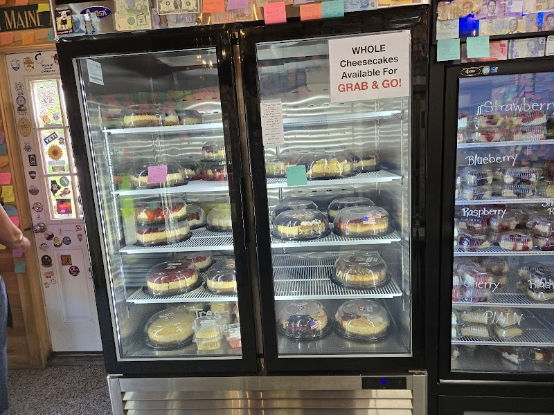Cheesecake display case in a park concession shop at Acadia National Park, showing an assortment of whole cheesecakes.
