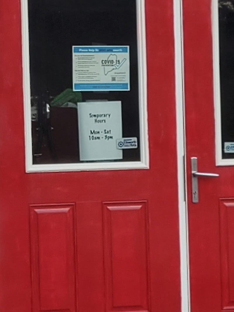 Bright red storefront of a gift shop in Acadia National Park, offering crafts and souvenirs, with posted notices in the window.