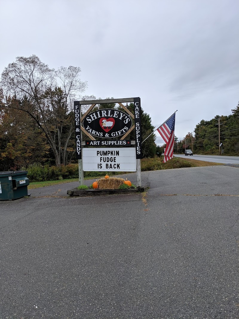 Gift shop sign near the road in Acadia National Park, with pumpkins and an American flag on display.