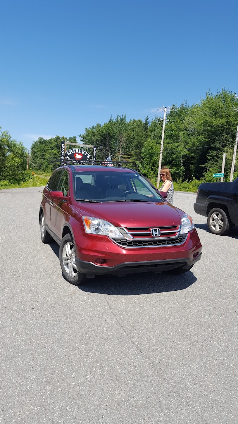 Gift shop storefront in Acadia National Park parking area, with a red Honda SUV in the foreground.