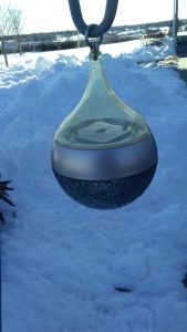 Lamoine glass wind ornament against a snowy backdrop near Acadia National Park.