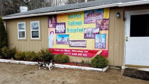 Mexican takeout storefront near Acadia National Park, shown by a beige building with a large colorful banner.