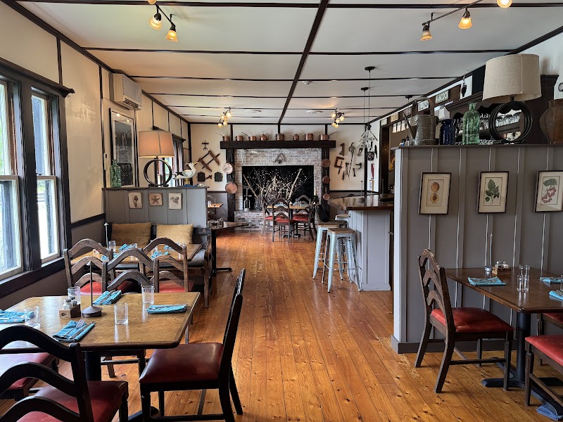 Cozy dining room at a restaurant in Acadia National Park features warm wood floors, rustic decor, and intimate booths.