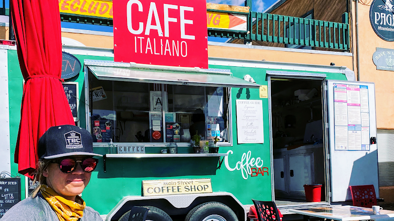 Green coffee truck with a red cafe-style sign at Arches National Park.