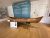 Long wooden canoe on display in a museum exhibit at Acadia National Park's visitor center, with a teal wall behind.