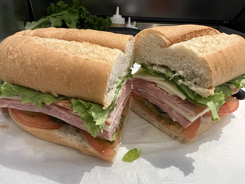 Two baguette submarine sandwiches stacked with lettuce, tomato, cheese and ham in Acadia National Park.