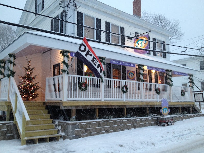 Morton’s Moo Homemade Ice Cream & Café in Acadia National Park sits on a snow-covered storefront with wreaths and a visible OPEN flag.