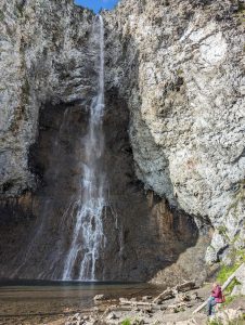 Fairy Falls waterfall at Yellowstone National Park cascades down a rugged rocky wall.