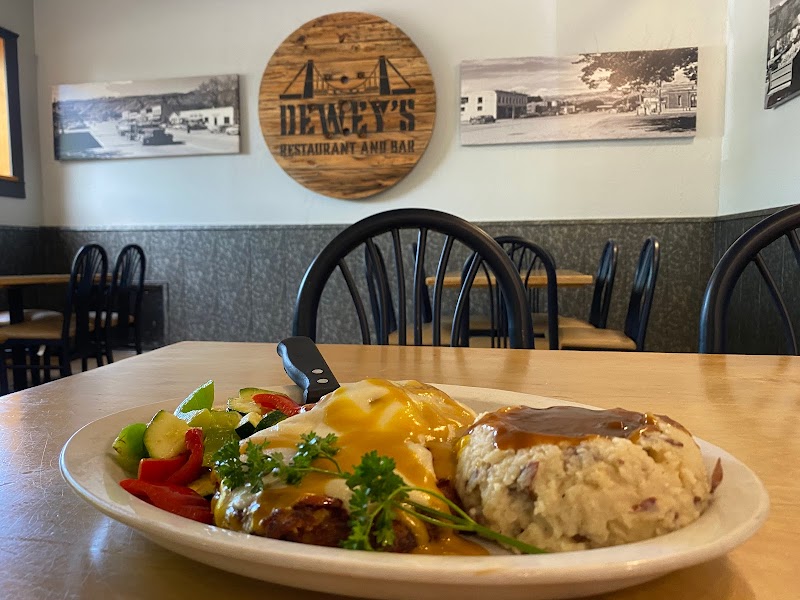 Casual diner interior with black chairs and wood tables; plated breakfast with eggs, potatoes, fruit, and parsley, in Arches National Park.