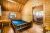 Interior of a rustic log cabin at Yellowstone National Park campground, featuring a simple wooden bed and a small desk.