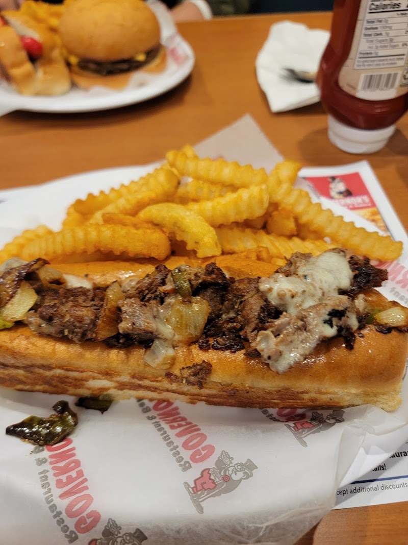 Beef hot dog topped with onions and melted cheese, served with crinkle-cut fries at a park dining spot in Acadia National Park.