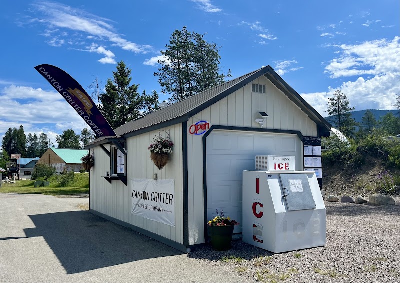 Small glacier park cafe near an ice vending unit sits beside a gravel lot at Glacier National Park.