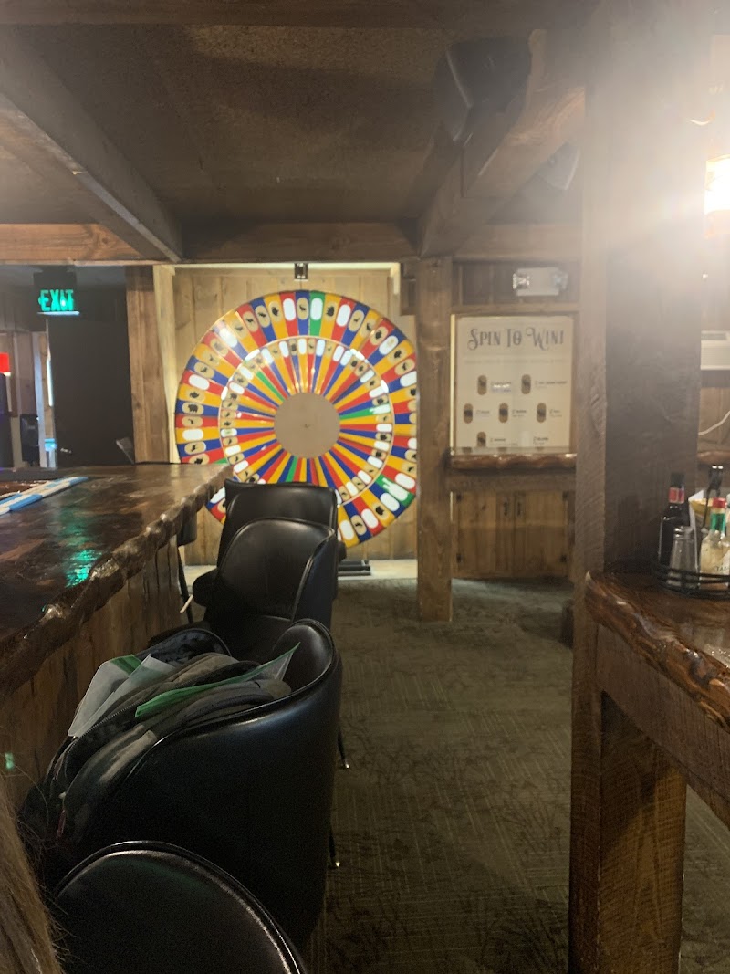 Inside a rustic bar at Yellowstone National Park, a bright multicolored wheel spins near the wooden counter and leather chairs.