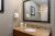 Hotel bathroom vanity at Acadia National Park lodging with granite countertop and framed mirror.